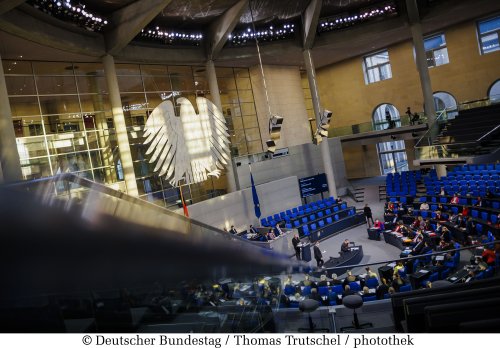 Foto des Plenarsaals des Deutschen Bundestags mit großen Bundesadler und Plenarsitzen