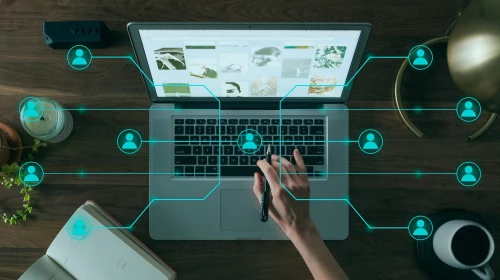 Hintergrund: Foto von einer Hand auf der Tastatur eines Laptops, Vordergrund: über das Foto gelegt ist ein mit Verbindungslinien und Figuren symbolisch dargestelltes digitales Netzwerk von Personen